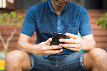 man holding smart phone for use internet with vintage tone. subject is blurred.