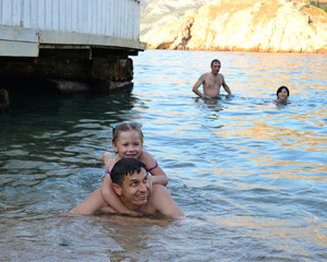 a man with a child happily swim in the sea  