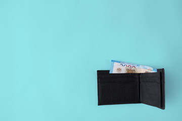Leather wallet with money on blue background