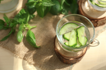 Glass cup of tasty cucumber water on table