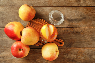 Ripe juicy apples with honey on wooden table