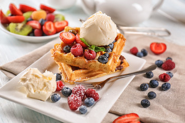 Delicious waffles with berries and ice cream on plate