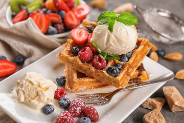 Delicious waffles with berries and ice cream on plate