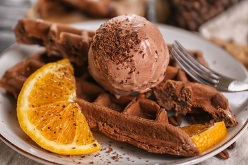 Delicious waffles with orange slices and ice cream on plate