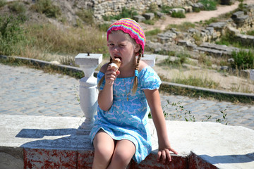 portrait of a girl in a blue summer dress eating ice cream  