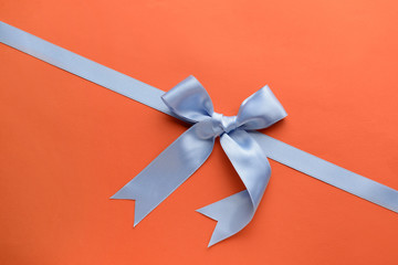 Blue ribbon with bow on color background