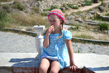 portrait of a girl in a blue summer dress eating ice cream  
