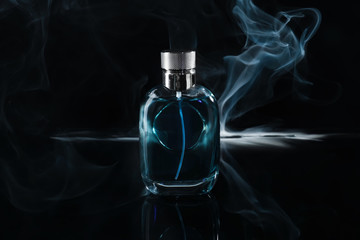 Bottle of perfume with fume on dark background