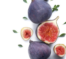 Whole and cut ripe figs on white background