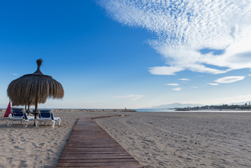 Playa solitaria con sombrillas de la ciudad de Cambrils en Tarragona, Costa Dorada,...