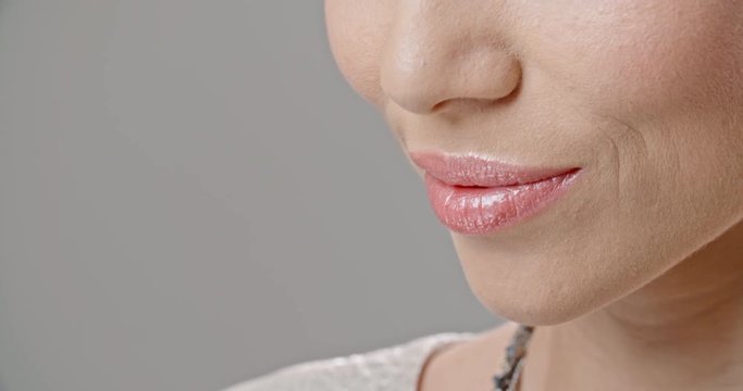 Young south asian model with fancy make-up and pink lipstick on lips smiling with a positive smile and blinking - extreme closeup 4k