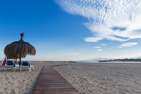 Playa solitaria con sombrillas de la ciudad de Cambrils en Tarragona, Costa Dorada, Catalu&ntilde;a.Espa&ntilde;a