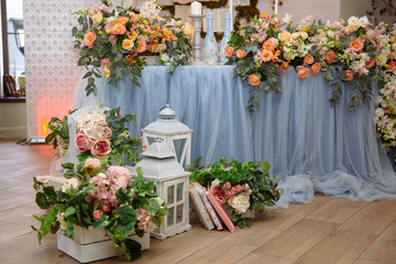 Fototapeta premium The table of the newlyweds is decorated with flowers, candles and fabrics. Concept of a wedding celebration, party, celebration of lovers, decor.