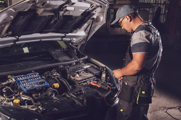 Car service worker diagnoses car breakdown.