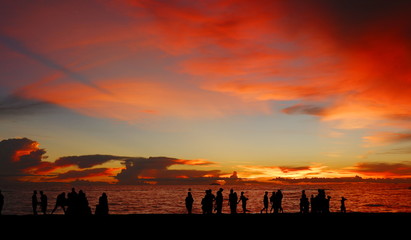 Silhouette of many people on the beach with seascapes on twilight sunset sky background