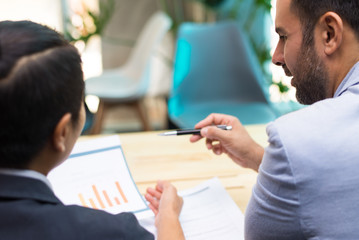 Back view of financial experts working together in office. Hispanic businessman working on...