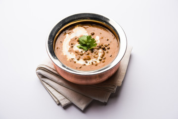 Dal makhani / makhni is a popular dish from India. Made with ingredients like whole black lentil, butter and cream. Served with Naan/roti and rice