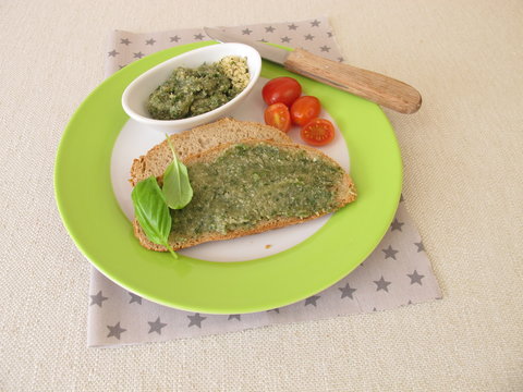 Selbstgemachte vegane Hanfpaste mit Basilikum auf einer Scheibe Brot