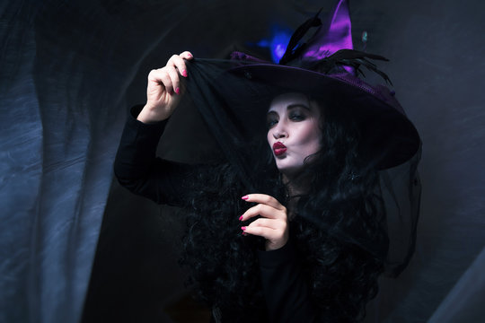 Halloween Witch Beautiful young woman in witches hat and costume