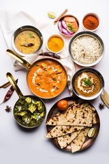Indian Lunch / Dinner main course food in group includes Paneer Butter Masala, Dal Makhani, Palak Paneer, Roti, Rice etc, Selective focus
