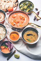 Indian Lunch / Dinner main course food in group includes Paneer Butter Masala, Dal Makhani, Palak Paneer, Roti, Rice etc, Selective focus