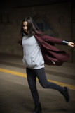 Photo of young woman in night subway walking forward