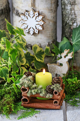 Candle holder made of cinnamon sticks and moss.