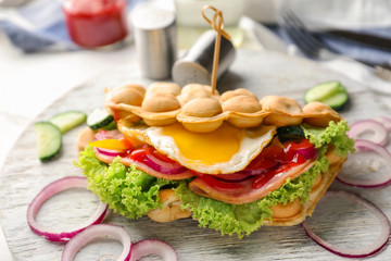 Delicious bubble waffle with fried egg on wooden board
