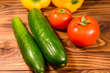 Cucumbers, tomatoes and sweet pepper on wooden table