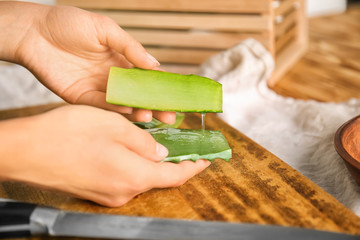 Woman holding cut aloe vera, closeup
