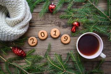 Christmas picture with the number 2019 on round cookies with a cup of tea on a wooden background