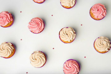 Delicious cupcakes on white background, flat lay