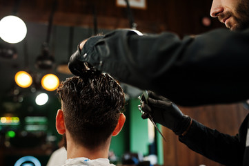 Handsome bearded man at the barbershop, barber at work.