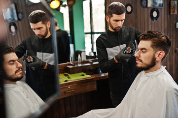 Handsome bearded man at the barbershop, barber at work.