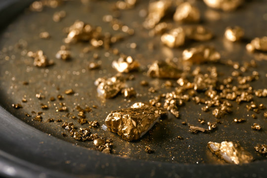 Gold nuggets on metal plate, closeup
