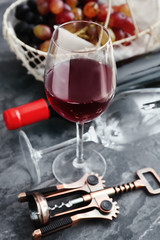 Glass of red wine and corkscrew on table