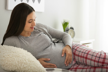 Beautiful pregnant woman resting in bedroom