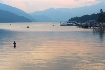 Nikko, Tochigi Prefecture, Japan - July 9, 2017: A man stands fishing at Lake Chuzenji