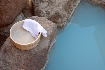 Bath bucket with towel at Japanese hot spring　温泉露天風呂の桶とタオル