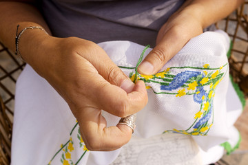 cross-stitch embroidering by woman