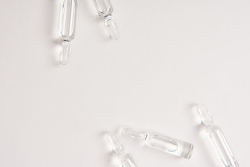 elevated view of ampoules with medical liquid on white surface
