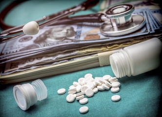 phonendoscope on American tickets, boat of white pills, conceptual image