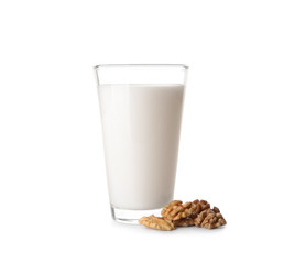 Glass of milk and walnuts on white background