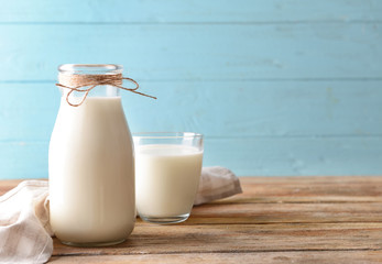 Bottle and glass of milk on wooden table