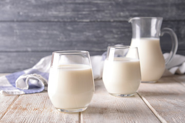 Glasses of milk on wooden table