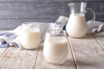 Glasses of milk on wooden table
