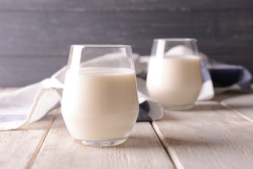 Glasses of milk on wooden table