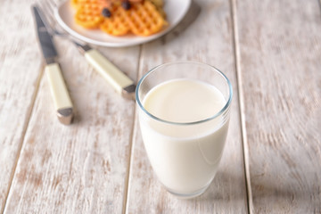Glass of milk on wooden table