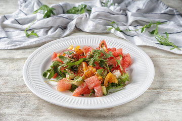 Plate with delicious watermelon salad on white wooden table