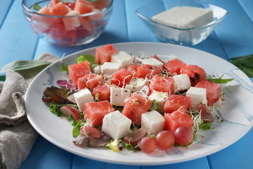 Plate with delicious watermelon salad on color wooden table, closeup